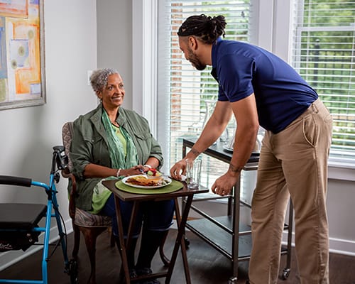 caregiver serving a resident food