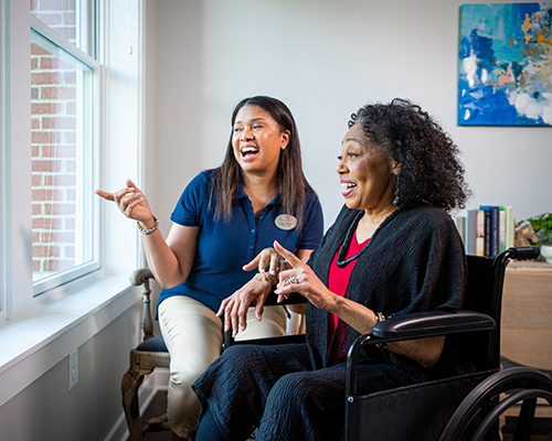 caregiver and resident looking out window